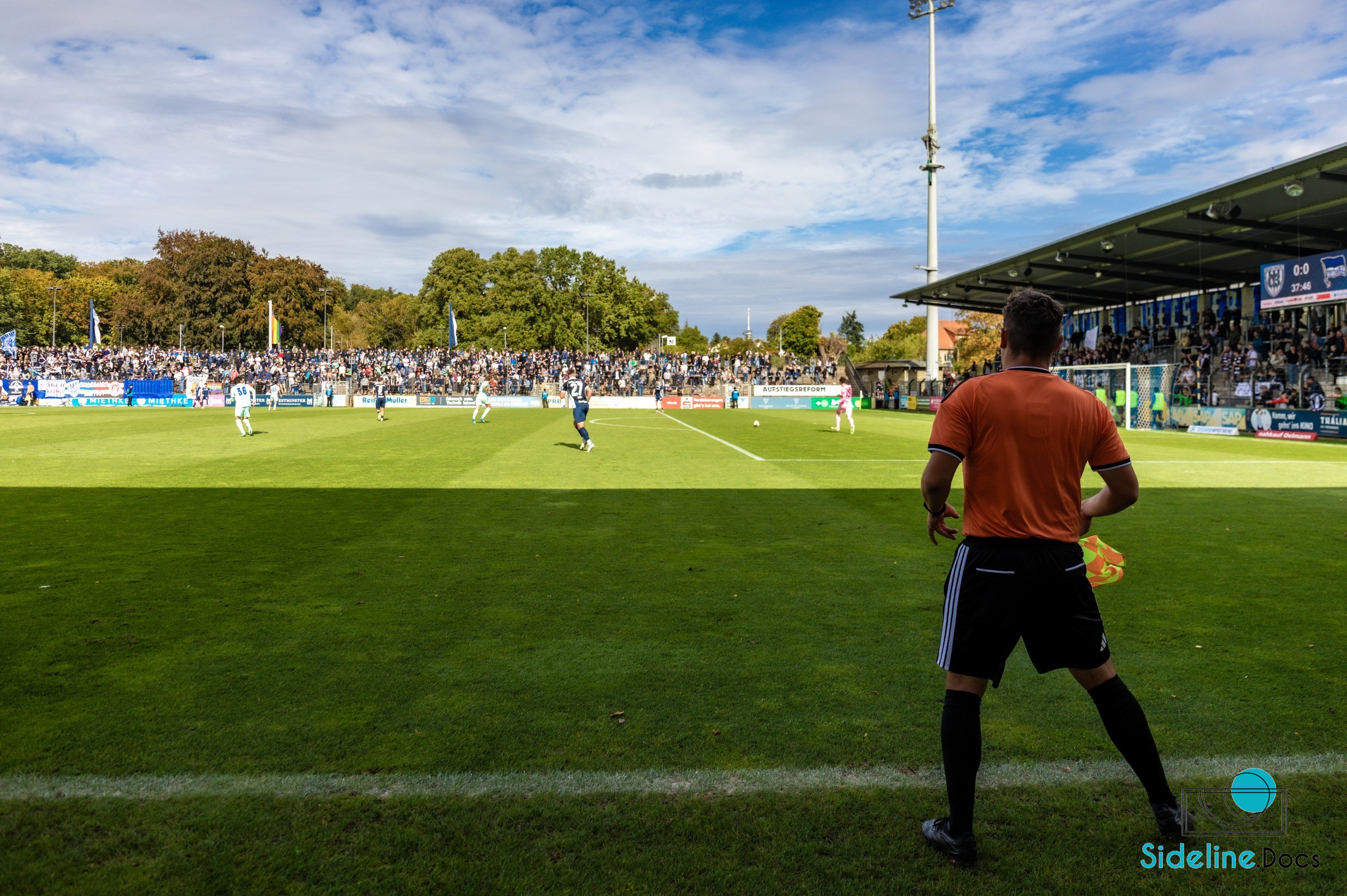 Wide match view with assistant referee in the foreground