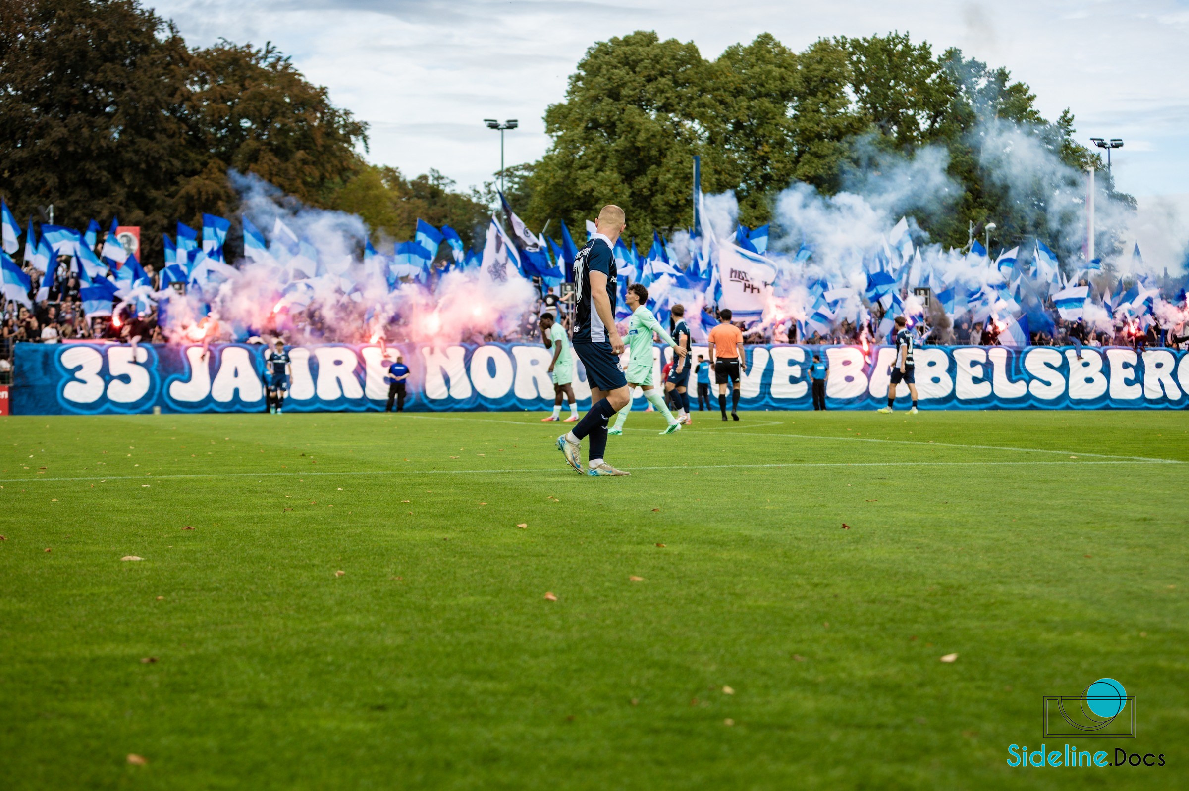 North stand pyrotechnics with flags and anniversary banner