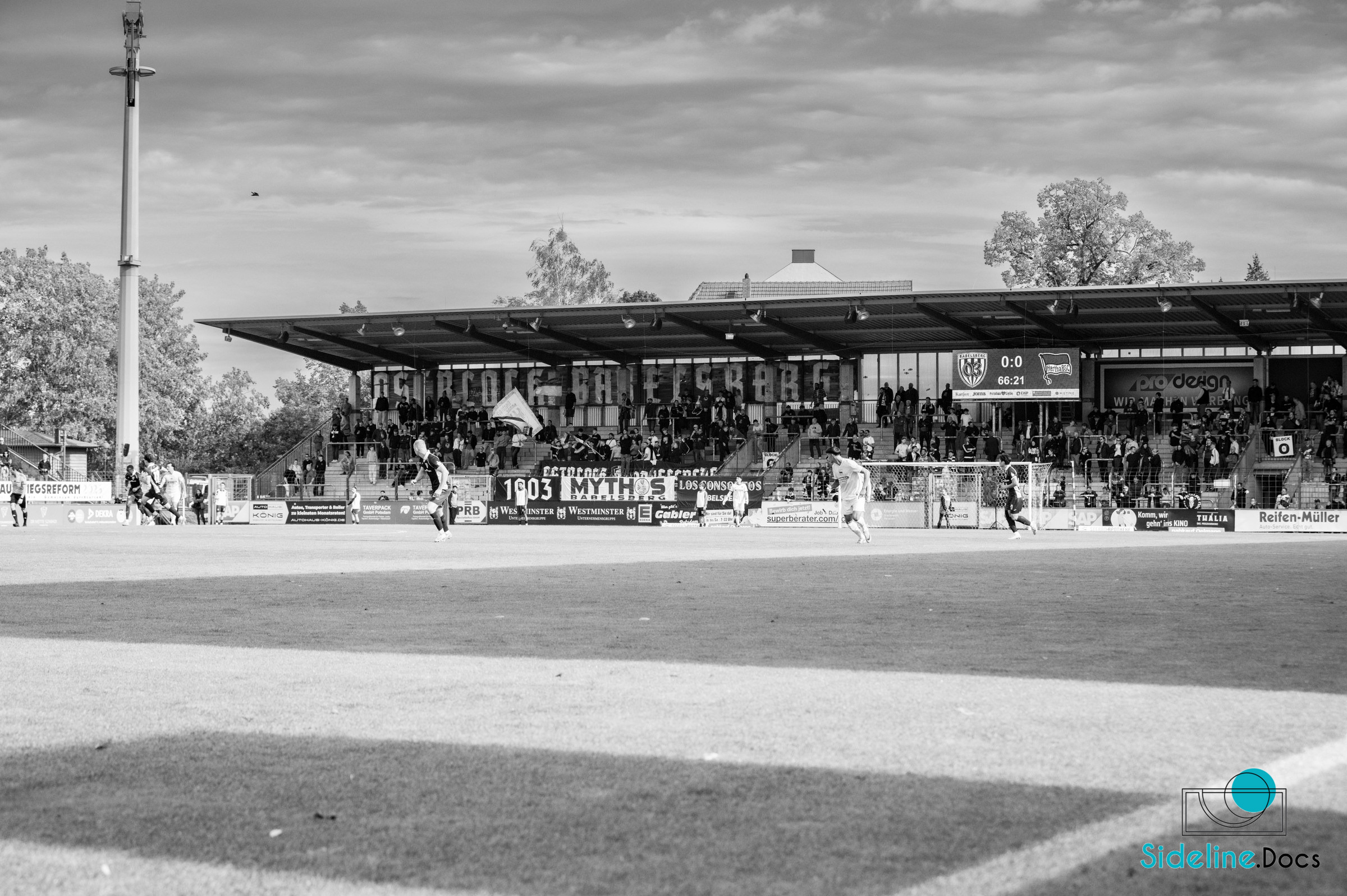 Black-and-white: wide match view in front of the main stand