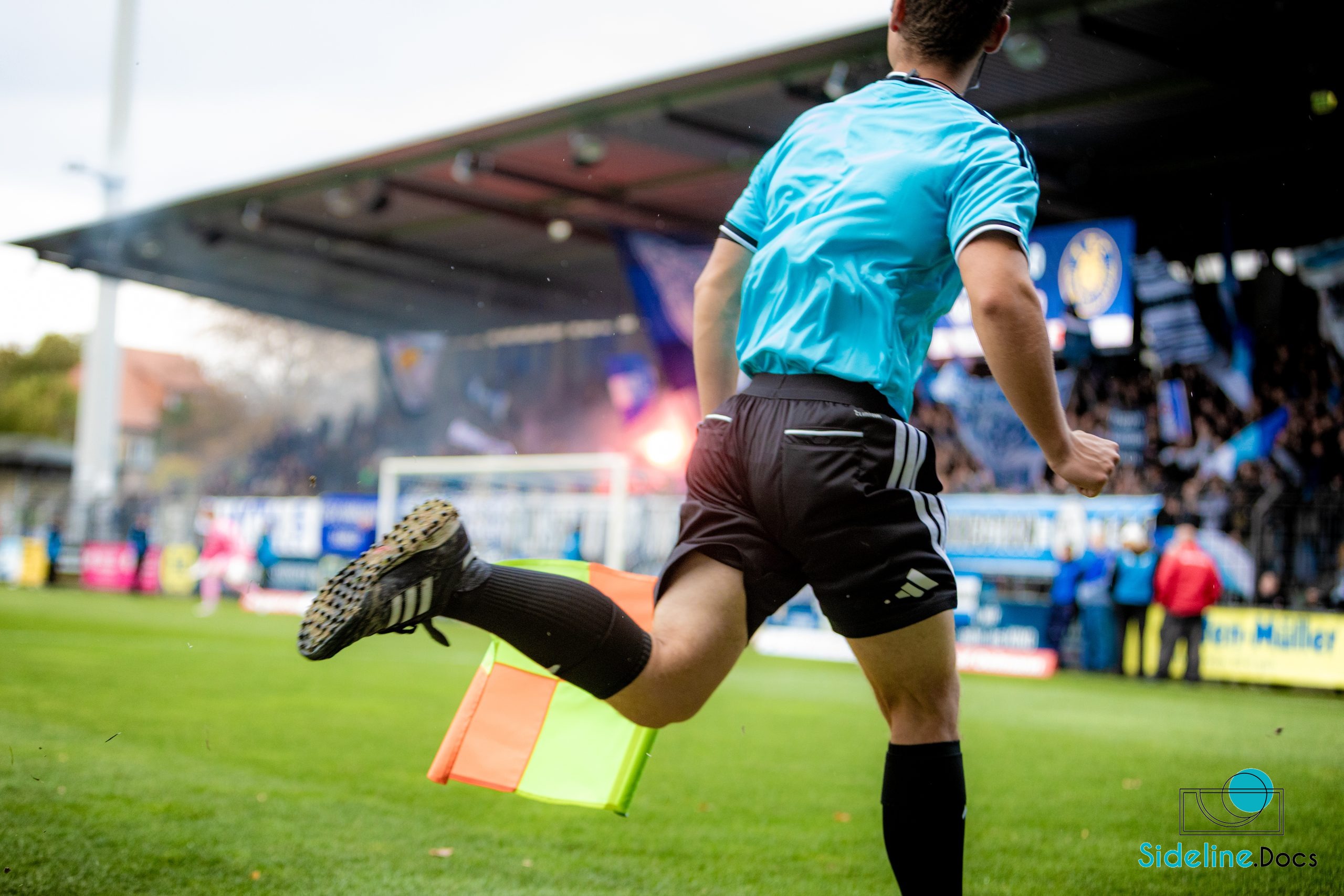 Sideline perspective behind the assistant referee