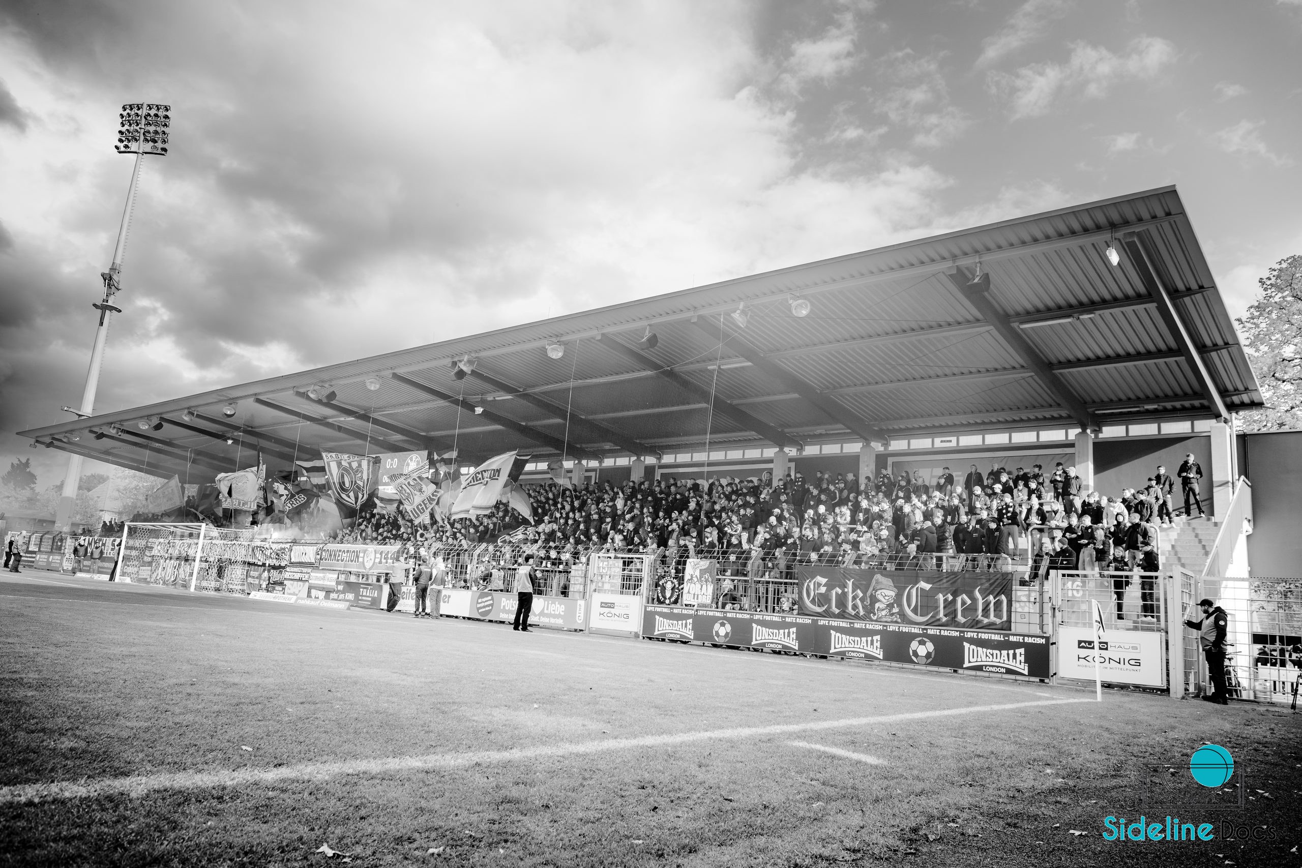 Covered stand with Eck Crew banner and flags under the roof