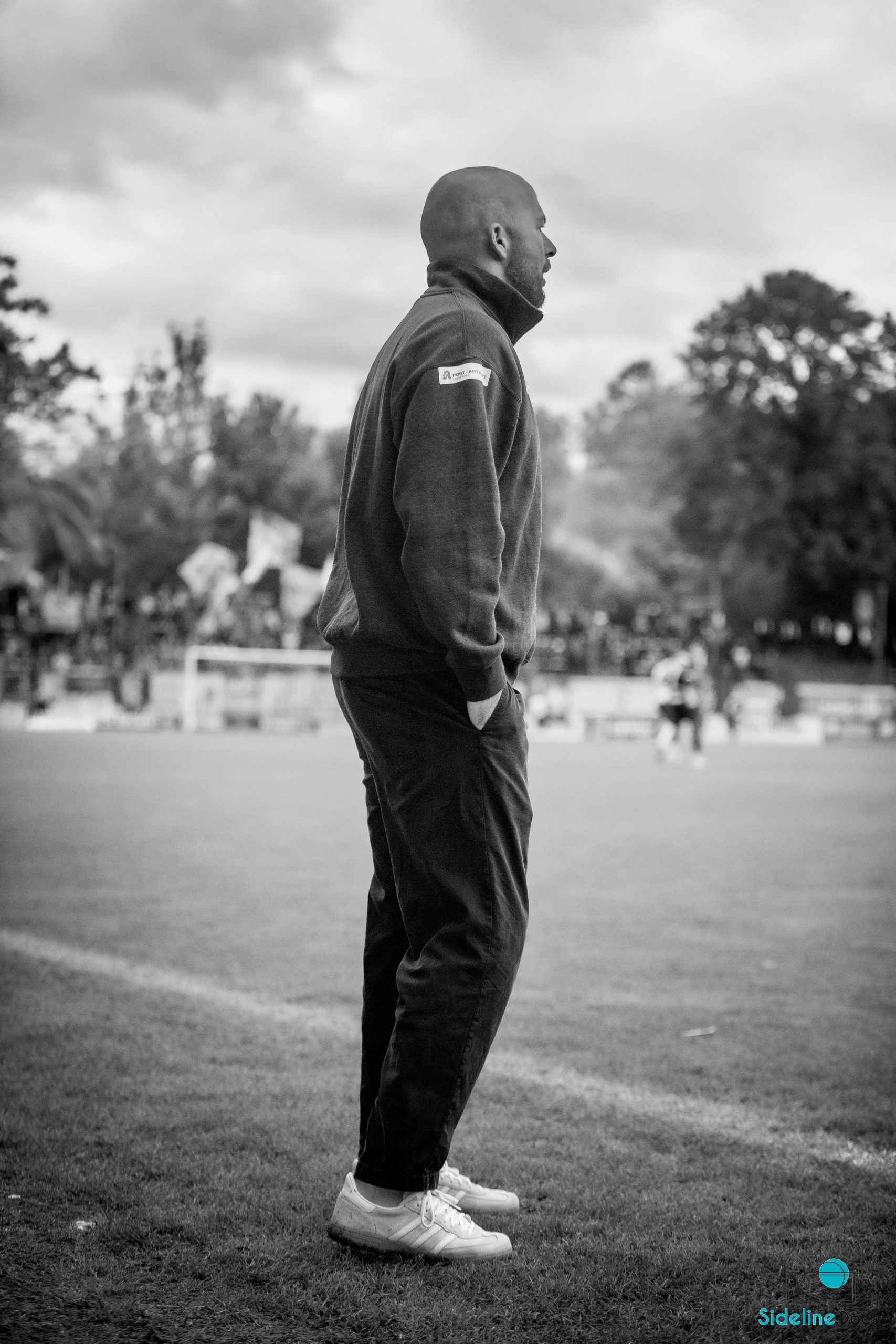 Coach on the touchline calling toward the pitch