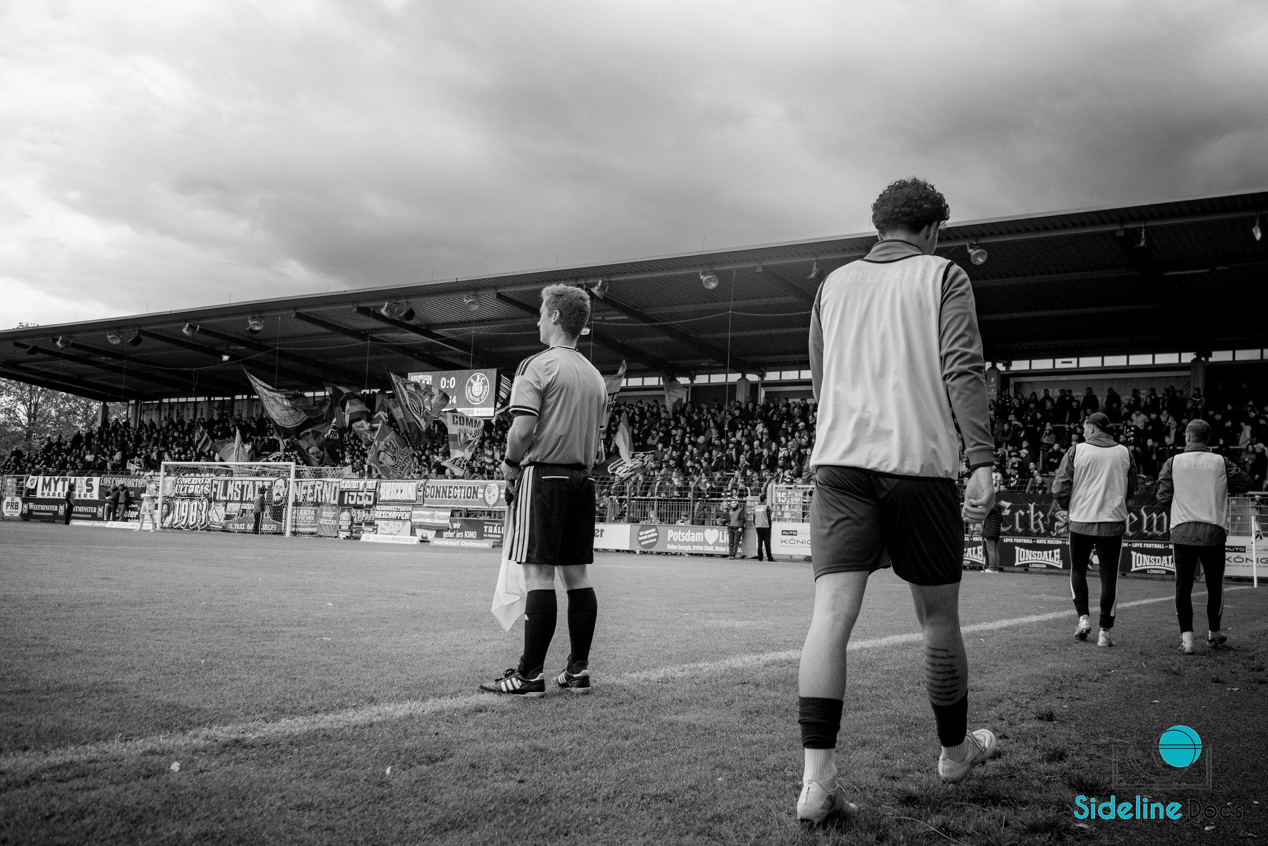 Assistant referee and substitutes facing the home stand