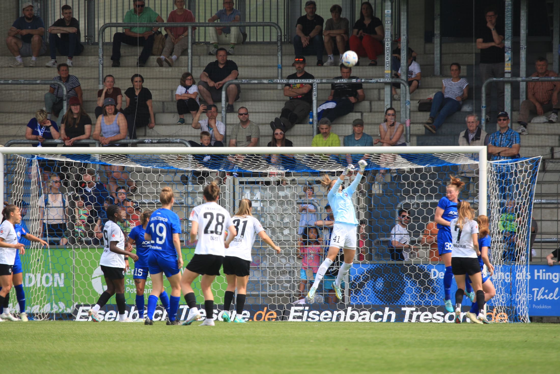 Penalty-box scene, goalkeeper reaching for the cross