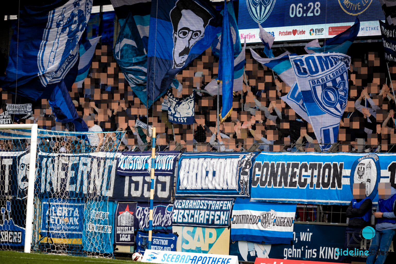 Home stand with Filmstadt Inferno banners and blue-and-white flags early in the match